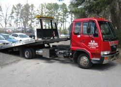 Flatbed Tow Truck with deck tilted for ramp loading