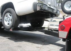 Wheel Lift Tow Truck with hydraulic lifting and winch for vehicle recovery services.